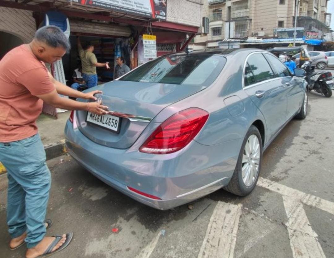 Number plate being fitted to a Mercedes S-Class outside the M7WRAP shop
