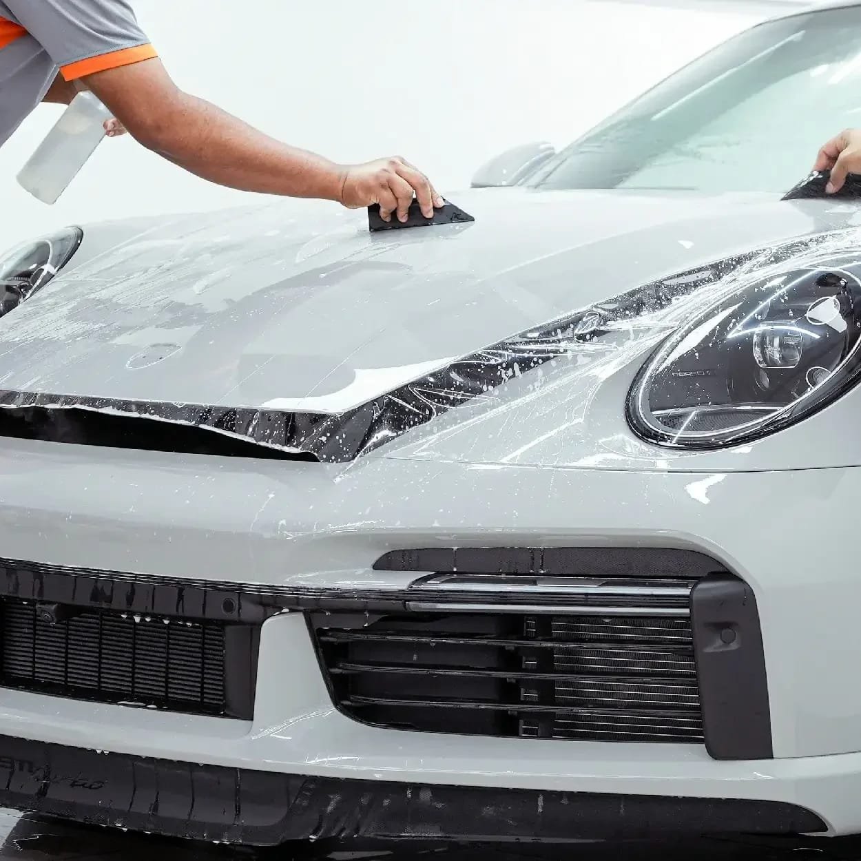 Paint protection film being installed on a sports car bonnet