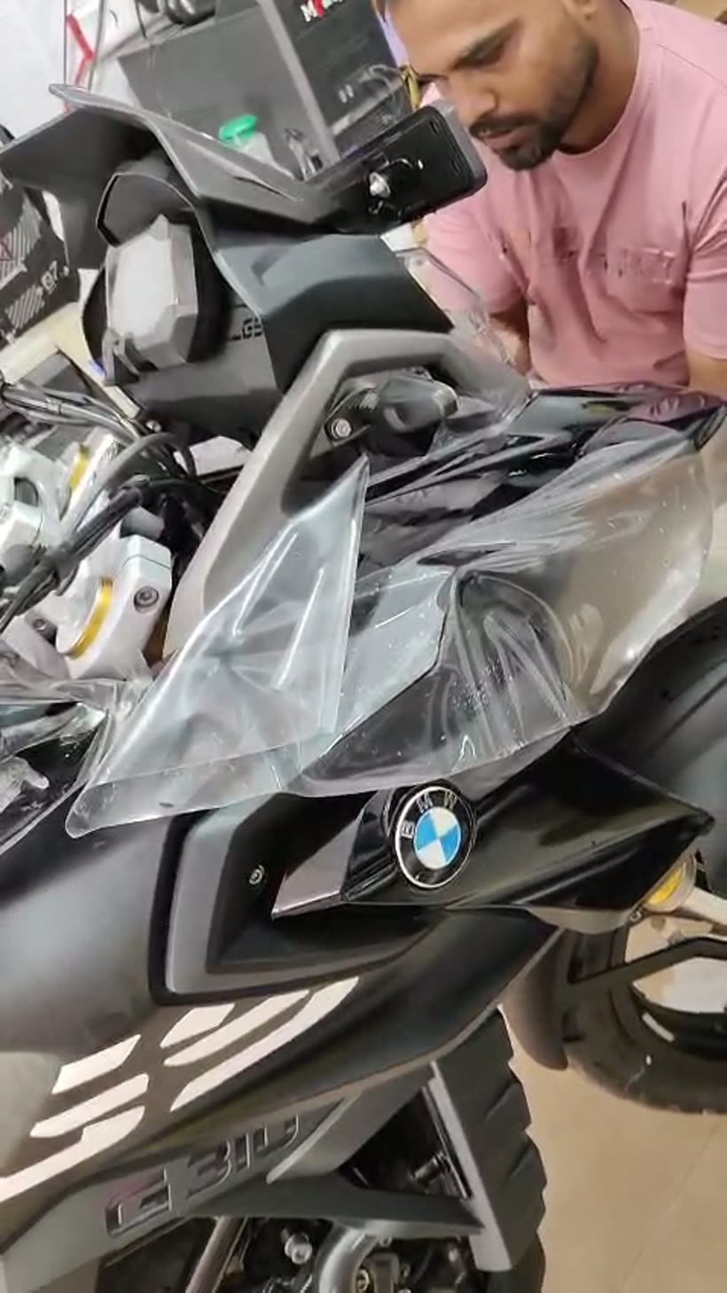 Paint protection film being wrapped over the front fairing of a BMW G310