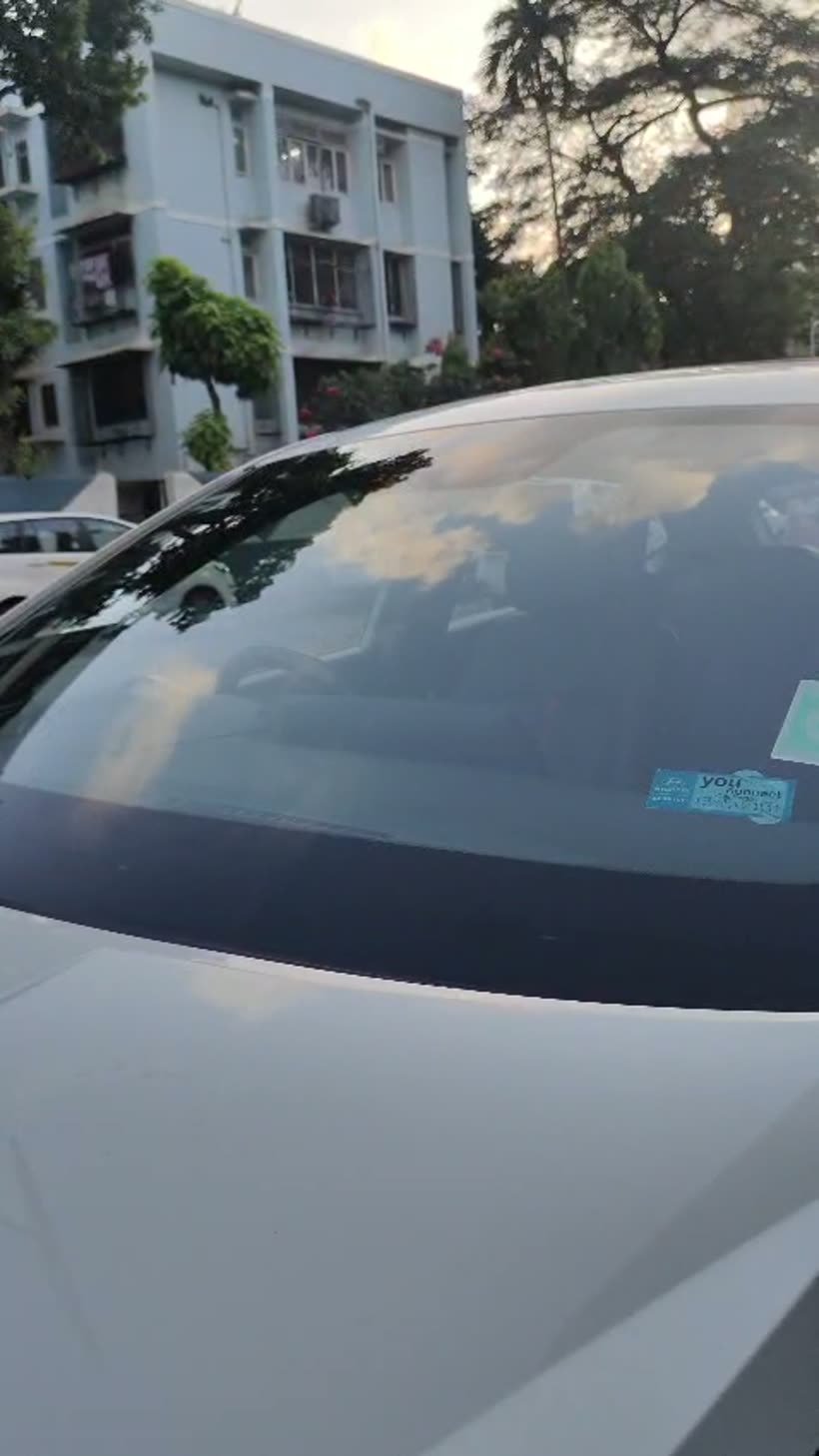 Sealed Garware Suncontrol film roll held over a car windshield